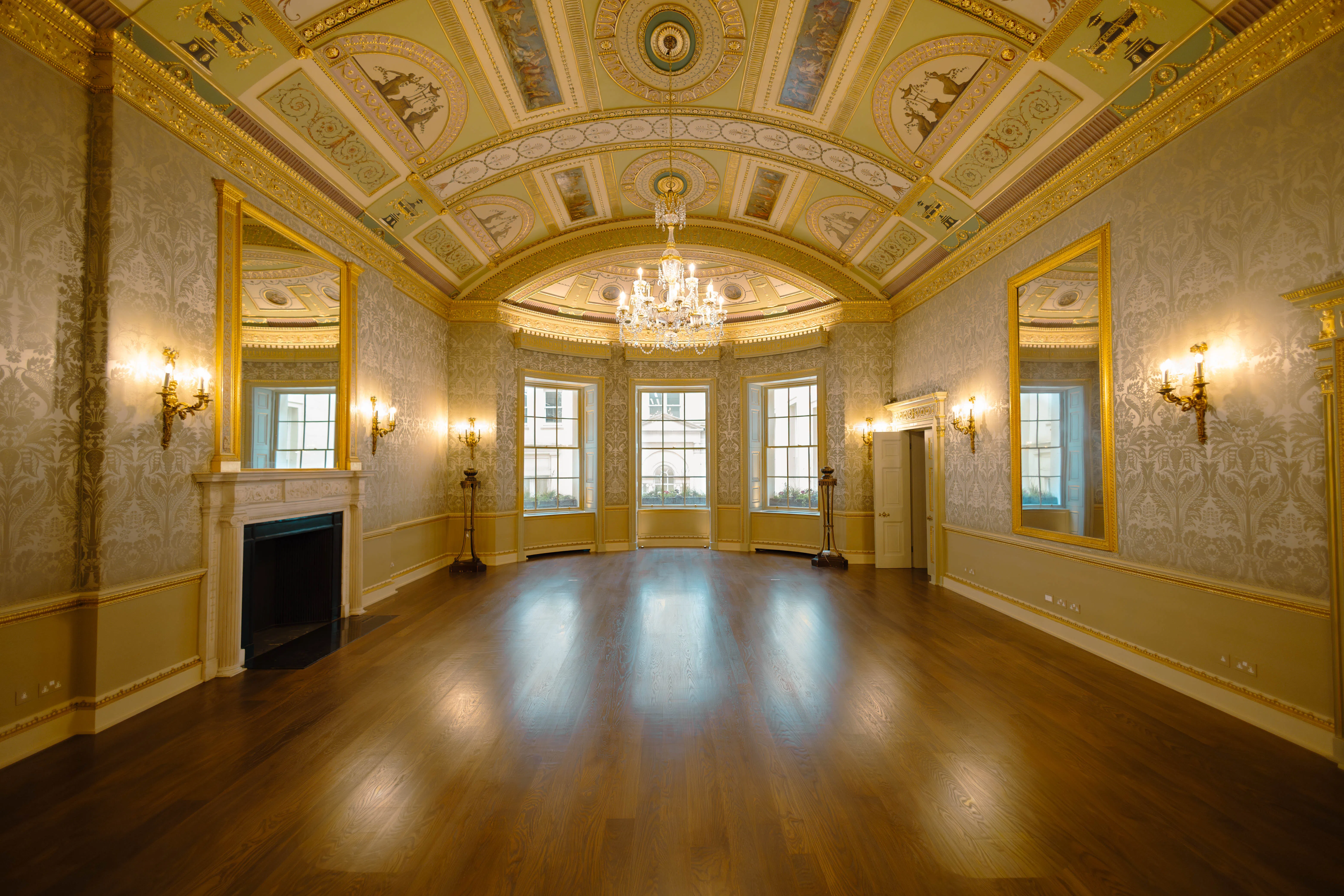 Grand period room with chandelier, fireplace and tall sash windows